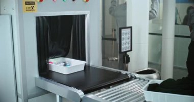 Havaalanı Güvenlik Kontrol Noktası: Güvenlik Subayının bavulları ve kişisel eşyaları X-ray taramasıyla taşınma bandına koyması. Metal dedektör kapısından geçen insanlar. TSA Tarama Prosedürleri.