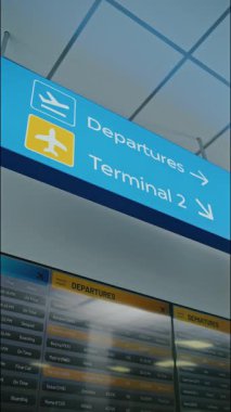 Uluslararası Havalimanı Terminali: Aydınlatılmış Parlak LED Tabelası Yolcuları Uçuş için Gidiş ve Terminallere Yönlendiriyor, Tavanda Asılı. Geliş ve Gidiş Dijital Kurulu. Dikey Çekim