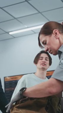 Havaalanındaki güvenlik kontrol noktası: Yolcu Bagajında Uçuş öncesi X-ray taraması için kadın TSA işçisi kontrol ediliyor. Çeşitli İnsanlar, Gezginler Tarama Prosedürleri Sırası. Dikey Çekim