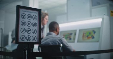 Havaalanı Güvenlik Kontrol Noktası: Bagaj Kısıtlamaları İmza. Modern Programı Kullanarak Bilgisayar Ekranlarında Bagaj Tarama İşlemlerinin X-ray görüntülerini izleyen İki Çoklu Etnik Güvenlik Memuruna Odaklan.