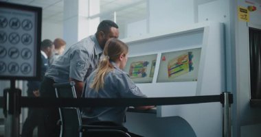 Havalimanı Güvenlik Kontrol Noktası: Modern Programı kullanarak Bavulun X-ray taramasını kontrol eden iki farklı TSA çalışanı. Gelişmiş Bagaj Tarama İşlem Teknolojisi, Metal Detektörü.