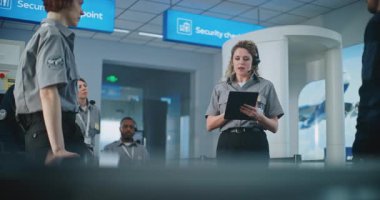 Havaalanı Güvenlik Sistemi: Tablet Bilgisayarlı Kadın Güvenlik Görevlisi, Yolcuların Taranması Hakkında Kontrol Noktası, TSA Uçuş Tarama Prosedürleri 'nde Havalimanı Personelini Eğitti.