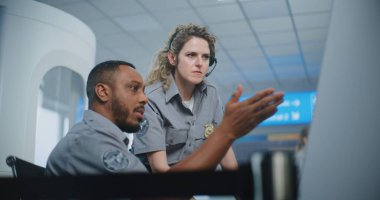 Güvenlik Kontrol Noktası 'ndaki havaalanı personeli: İki çok ırklı TSA subayı konuşuyor, Uçuş Bilgisayarı Kullanarak Uçuş İzleme Prosedürü uyguluyor. Seyahat Güvenliği Ulaştırma Güvenlik Yönetimi