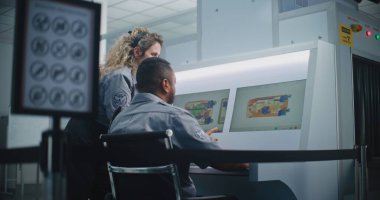 Havaalanı Güvenlik Kontrol Noktası: Bagaj Kısıtlamaları İmza. Modern Yazılım kullanılarak bilgisayar ekranları üzerindeki bagaj tarama işleminin X-ray tarama görüntülerini analiz eden iki farklı TSA memuruna odaklan.