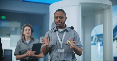 Havaalanı Personel Brifingi: Afrikalı Amerikan Güvenlik Subayı Planlama Oturumu, TSA Tarama Prosedürleri hakkında İşçi Grubuna Talimatlar Verme. Ulaştırma Güvenlik Yönetimi.