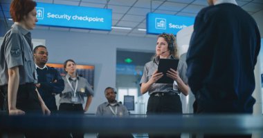 Havaalanı Güvenlik Sistemi: Tablet Bilgisayarlı Kadın Güvenlik Görevlisi, Yolcuların Taranması Hakkında Kontrol Noktası, TSA Uçuş Tarama Prosedürleri 'nde Havalimanı Personelini Eğitti.