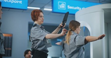 Havalimanı Personel Eğitimi: İşçi Grubuna Talimat Veren Kadın Güvenlik Görevlisi, Yolcuların Metal Detektör Taramasını Gösterme, Uçuş için Tarama Prosedürleri.