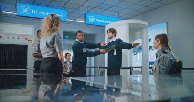 Havaalanı Personel Eğitimi: Afrikalı Amerikan Güvenlik Subayı İşçi Grubuna Talimat Veriyor, Yolcuların Metal Detektör Taramasını Gösteriyor, Uçuş için Tarama Yöntemleri.