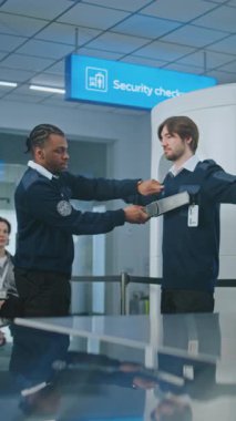 Havaalanı Personel Eğitimi: Afrikalı Amerikan Güvenlik Subayı İşçi Grubuna Talimat Veriyor, Metal Detektör Taraması Sürecini Gösteriyor, Uçuş için Tarama Yöntemleri. Dikey Çekim.