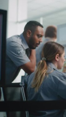 Havaalanı Güvenlik Kontrol Noktası: Bagaj Kısıtlamaları İmza. Bilgisayar Yazılım Kullanarak Bilgisayar Ekranları 'ndaki bagaj taramasının X-ray tarama görüntülerini analiz eden iki farklı TSA memuruna odaklanın. Dikey Çekim.