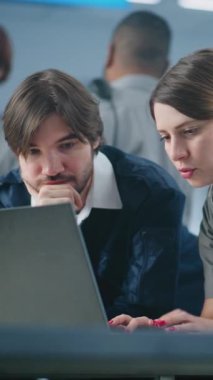 Havaalanı Güvenlik Kontrol Noktası: Laptop kullanan iki farklı havaalanı işçisi, güvenlik konularını tartışıyor. Ulaşım Güvenlik İdaresi. Arka planda, havaalanı personeli çalışıyor. Dikey Çekim.