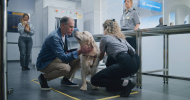 Havalimanı Terminalindeki Hayvan Bakım İşlemi sırasında Olgun Adam: Kadın TSA Uzmanı Köpeği İnceleme ve Tarayıcı Metal Detektörü Kullanıyor. Uçağa binmek için Güvenlik Kontrol Noktasında Hayvan Denetleme.