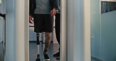 Güvenlik Kontrol Noktasındaki Çeşitli Gezginler: Protez bacaklı adam ve X-ray Metal dedektöründen geçen yetişkin kadın havaalanı terminalinde. Uçağa binmek için yolcu tarama prosedürleri.