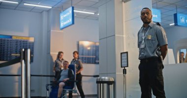 Havaalanı Terminali 'ndeki güvenlik kontrol noktası: Tekerlekli sandalyedeki protez bacaklı genç adamı denetleyen Afrikalı Amerikan Güvenlik Subayı. Uçağa binmek için tarama prosedürleri. Engelli Turist.