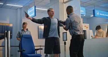 Havaalanı Terminali 'ndeki güvenlik kontrol noktası: Tekerlekli sandalyedeki protez bacaklı genç adamı denetleyen Afrikalı Amerikan Güvenlik Subayı. Uçağa binmek için tarama prosedürleri. Engelli Turist.