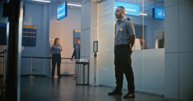 Havaalanı Terminali 'ndeki güvenlik kontrol noktası: Afro-Amerikan Güvenlik Subayı, Biniş Uçuşu için Protez Ayaklı Genç Adamı Denetliyor. TSA tarama prosedürleri. Engelli turist. Tam Vuruş.