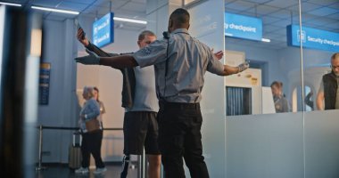 Güvenlik Kontrol Noktası: Afro-Amerikan Ulaşım Güvenlik Subayı Havaalanı Terminalinde Genç Adamı Protez Bacaklı Kontrol Ediyor. Uçağa binmek için yolcu tarama prosedürleri. Engelli Gezgin Seyahate Çıkıyor