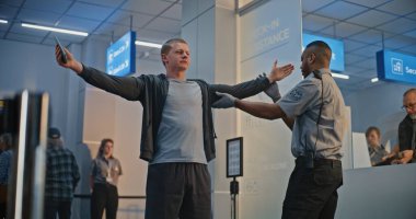 Havaalanı Terminali 'ndeki güvenlik kontrol noktası, Biyonik Protez Bacağı olan Afrikalı Amerikalı Güvenlik Subayı. TSA tarama prosedürleri. Engelli Turist.