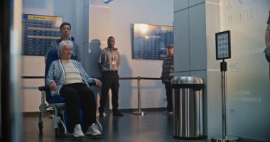 Güvenlik Kontrol Noktası: Havaalanı Terminali 'ndeki Yaşlı Kadın Tekerlekli Sandalyeden Kalkıyor. Uçağa binmek için yolcu tarama prosedürleri. Engelli kıdemli gezgin..