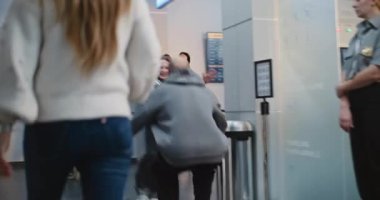 Havalimanı Terminali 'nden ailesini selamlayan mutlu adam kızını kucağına alır. Uzun bir ayrılıktan sonra duygusal aile buluşması. Yatılı Uçuşlar için Çeşitli İnsanlar Bavulla Yürüyor.