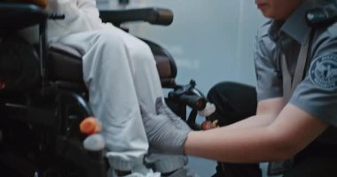 Güvenlik Kontrol Noktası: Havaalanı Terminali 'nde Engelli Kadın TSA Memurunun Kapanışı. Uçağa binmek için yolcu tarama prosedürleri. Tekerlekli sandalyedeki gezgin Seyahate çıkıyor.