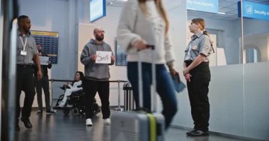 Uluslararası Havalimanı Terminali 'nde Ulaştırma Servisi: Havalimanı karşılama görevlileri isim işareti tutuyor, Uçak Yolcularını Bekliyor. Çeşitli İnsanlar ve Gezginler Bavulla Yürüyor. Tam Vuruş.