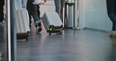Kalabalık Uluslararası Havaalanı Terminali: Uçağa binmek için bavulla birlikte yürüyen çeşitli insanların diz üstü çekimleri. Tekerlekli sandalyedeki engelli yolcu. Turizm ve Seyahat. Yavaş çekim.
