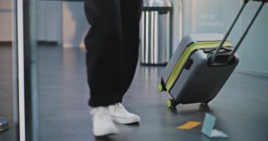 Kalabalık Uluslararası Havaalanı Terminali: Biniş uçuşu için bavullarla yürüyen çeşitli insanların diz üstü çekimleri. Tekerlekli sandalyedeki engelli yolcu. Turizm ve Seyahat. Yavaş çekim