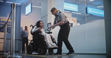 Güvenlik Kontrol Noktası: Havaalanı Terminali 'nde fiziksel engelli bir kadını kontrol eden kadın havaalanı görevlisi. Uçağa binmek için yolcu tarama prosedürleri. Tekerlekli sandalyedeki gezgin Seyahate çıkıyor.