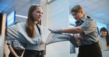 Havaalanı Terminali 'ndeki güvenlik kontrol noktası: Kadın memur, genç kızı denetliyor, tarama prosedürleri uyguluyor. Havaalanı işçisi uçağa binmek için kızla yürüyor. Genç Turist Tatile Çıkıyor.