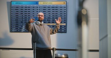 Kalabalık Uluslararası Havalimanı Terminali: Popüler Seyahat Blogcusu Video İçeriği, Havayolu Merkezinin Uçuş Bekleme Salonu. Trip 'e çıkan adam. Çeşitli İnsanlar ve Havalimanı Personeli Yürüyüşü.