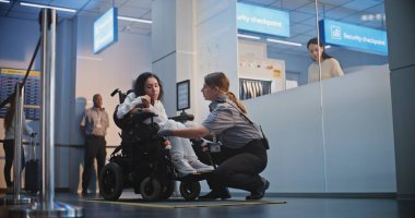 Güvenlik Kontrol Noktası: Havaalanı Terminali 'nde fiziksel engelli bir kadını kontrol eden kadın havaalanı görevlisi. Uçağa binmek için yolcu tarama prosedürleri. Tekerlekli sandalyedeki gezgin Seyahate çıkıyor.