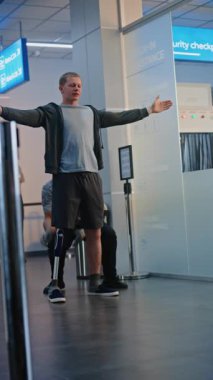 Güvenlik Kontrol Noktası: Havalimanı Terminali 'nde protez bacaklı bir adamı kontrol eden Afro-Amerikan havaalanı görevlisi. Uçağa binmek için yolcu tarama prosedürleri. Engelli bir gezgin. Dikey Çekim.