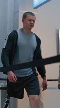 Güvenlik Kontrol Noktası: Havaalanı Terminali 'nde biyonik protez bacaklı bir adam X-ray metal dedektöründen geçiyor. Uçuş için yolcu tarama prosedürleri. Engelli bir gezgin. Dikey Çekim