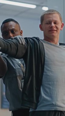 Güvenlik Kontrol Noktası: Afro-Amerikan Ulaşım Güvenlik Subayı Havaalanı Terminalinde Genç Adamı Protez Bacaklı Kontrol Ediyor. Uçağa binmek için yolcu tarama prosedürü. Engelli bir gezgin. Dikey Çekim