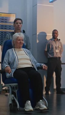 Güvenlik Kontrol Noktası: Havaalanı Terminali 'ndeki Yaşlı Kadın Tekerlekli Sandalyeden Kalkıyor. Uçuş için yolcu tarama prosedürleri. Engelli kıdemli gezgin. Dikey Çekim