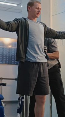 Güvenlik Kontrol Noktası: Afro-Amerikan Ulaşım Güvenliği Memuru Adamı Havalimanı Terminali 'ndeki tekerlekli sandalyede biyonik protez bacakla kontrol ediyor. Yolcu tarama prosedürü. Engelli bir gezgin. Dikey Çekim.