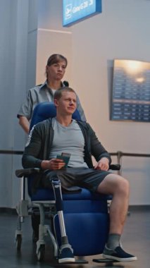 Havaalanı Terminali 'ndeki güvenlik kontrol noktası: Tekerlekli sandalyedeki protez bacaklı Afrikalı Amerikalı güvenlik görevlisi. Uçuş için tarama prosedürleri. Engelli turist. Dikey Çekim.