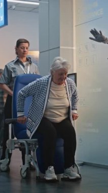 Güvenlik Kontrol Noktası: Havaalanı Terminali 'ndeki Yaşlı Kadın Tekerlekli Sandalyeden Kalkıyor. Uçuş için yolcu tarama prosedürleri. Engelli kıdemli gezgin. Dikey Çekim