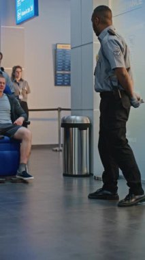 Havaalanı Terminali 'ndeki güvenlik kontrol noktası: Tekerlekli sandalyedeki protez bacaklı Afrikalı Amerikalı güvenlik görevlisi. Uçuş için tarama prosedürleri. Engelli turist. Dikey Çekim.