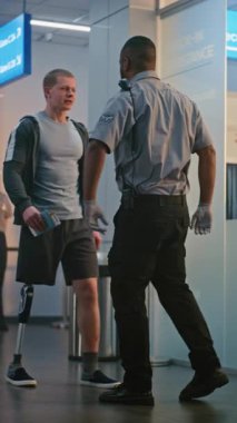 Havaalanı Terminali 'ndeki güvenlik kontrol noktası: Afro-Amerikan Güvenlik Subayı, Biniş Uçuşu için Protez Ayaklı Genç Adamı Denetliyor. TSA Tarama Prosedürü. Engelli turist. Dikey Çekim