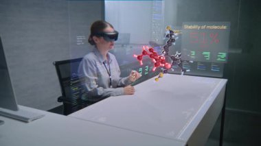 Gelişmiş Ofisteki Moleküler Bileşiklerin 3 boyutlu hologramını görüntülemek için Kadın Profesyonel Artırılmış Gerçeklik Kulaklığı Kullanıyor. Yapay Zeka Temelli Yazılım Arayüzünün Sanal Görselleştirilmesi.