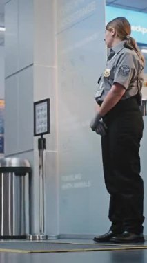 Kalabalık Havaalanı Terminali: Güvenlik Kontrol Noktası 'nda Güvenlik Personeli, Çeşitli İnsanlar ve Yolcular Bavulları Uçuşa Gidiyor, Varış ve Gidiş Kurulunu Denetliyor. Dikey Çekim