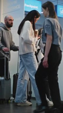 Yoğun Havaalanı Terminali: Ebeveynler ve Kızları Konuşuyor, Havaalanı Salonunda Uçuş Beklerken Kavga Ediyor. Aile tatili. Çeşitli İnsanlar ve Havalimanı Personeli Yürüyüşü. Dikey Çekim.