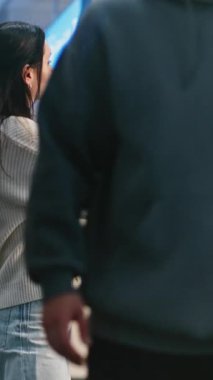 Kalabalık Havaalanı Terminali: Güzel Kadın Smartphone 'da Selfie Çekiyor, Uçağın Bekleme Salonunda Bekliyor. Seyahate çıkan bir turist. Çeşitli İnsanlar ve Havalimanı Personeli Yürüyüşü. Dikey Çekim