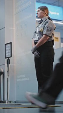 Kalabalık Uluslararası Havaalanı Terminalinde Bavulda Yürüyen Yolcular. Kadın Güvenlik Subayı, kadının uçağa binmek için kapı bulmasına yardım ediyor. Seyahate çıkan gezginler. Dikey Çekim