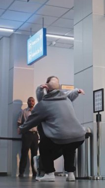 Havalimanı Terminali 'nde İç açıcı Aile Buluşması: Mutlu Adam Uçak Uçuşundan Ailesiyle Tanışıyor, Kızını Kollarıyla Kaldırıyor. Çeşitli insanlar, bavulla yürüyen yolcular. Ağır çekim. Dikey Çekim