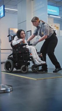 Havaalanı Terminali 'ndeki Güvenlik Kontrol Noktası Tekerlekli Sandalyedeki Kadın Güvenlik Görevlisi Uçak Uçuşu için. TSA tarama prosedürleri. Fiziksel Engelli Turist. Dikey Çekim.