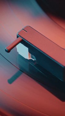 Vinil Plak Oynatıcı: Vinil Plak Döndürme ve Retro Turntable 'da Çalma Sesi Red Neon Lightning tarafından aydınlatıldı. Klasik Müzik Koleksiyonu için Klasik Ses Sistemi. Makro Yakın çekim. Dikey Çekim.