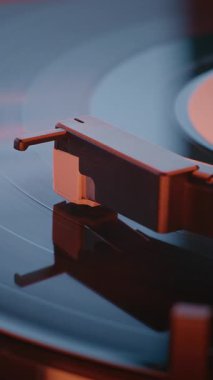Old School Vibe Plak Oynatıcı: Macro Close Up of Vinyl Record Spinning, Playing Sound on Retro Turntable Illuminted by Red Neon Lightning. Klasik Müzik için Klasik Ses Sistemi. Dikey Çekim.